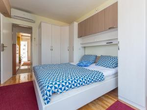 a bedroom with a large bed with blue and white sheets at Romantic apartments Marko for 2 with pool and grill in Zaton