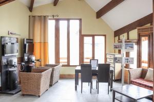 a dining room with a table and chairs andwindows at Residence Les Terrasses d'Azur - maeva Home in Isola 2000