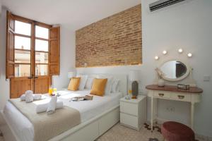 a bedroom with a bed with a mirror and a table at SingularStays Gulliver in Valencia