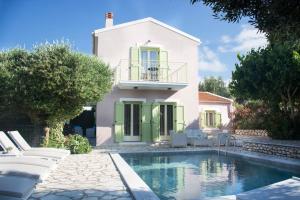 a house with a swimming pool in front of a house at Villa Kalogris in Fiskardo