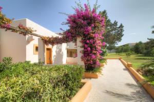a house with pink flowers on the side of it at Hotel Club Sunway Punta Prima in Es Pujols