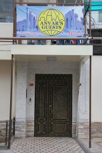 uma placa acima de uma porta para um hotel com uma entrada em Anvar's Guests em Tashkent