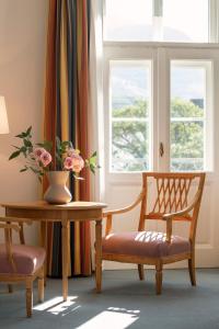 a room with a table and chairs and windows at Parkhotel Laurin in Bolzano
