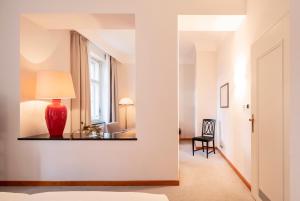 a room with a red vase on a shelf on a wall at Parkhotel Laurin in Bolzano
