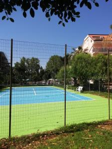 un campo da tennis visto attraverso una recinzione di Bouganville Residence a Calatabiano