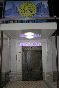 einen Eingang zu einem Hotel mit einer großen Holztür in der Unterkunft Anvar's Guests in Taschkent