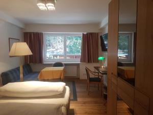 Cette chambre comprend 2 lits et une table. dans l'établissement Comfort Rooms Bruckner, à Bad Gastein