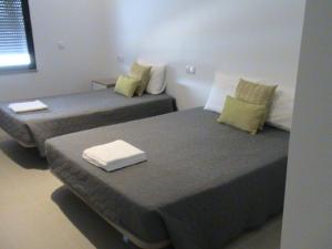 Dos camas en una habitación de hotel con toallas. en RM newhost 2015 / CasaDoChico, en Portalegre