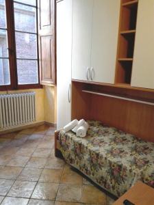 1 dormitorio con 1 cama con toallas en HostelCiompi en Siena