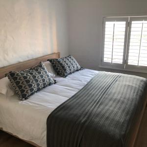 a bed with two pillows on it in a bedroom at The Sanctuary Penthouse in Plettenberg Bay