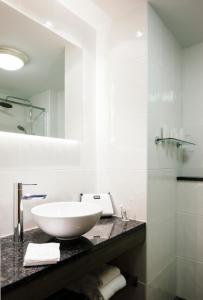 Brandon House Hotel في نيو روس: حمام أبيض مع حوض ومرآة