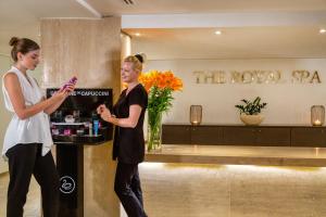 two women standing at a bar in a hotel lobby at Royal Apollonia by Louis Hotels in Limassol