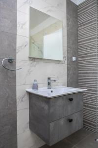 un baño con lavabo y espejo en Apartman Diva, en Orebić