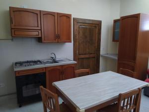een keuken met houten kasten, een tafel en een wastafel bij Come a Casa - Like home in Tocco da Casauria