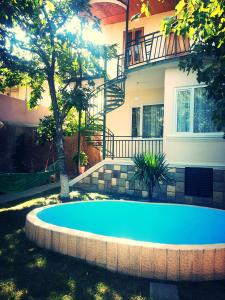 a swimming pool in front of a house at Natalie's Guest house in Tbilisi City