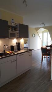 eine Küche mit weißen Geräten und ein Esszimmer in der Unterkunft Loui´s FeWo Wiek in Wiek auf Rügen 