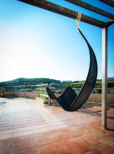 a pair of black shoes hanging from a pole on a roof at Apollonia Hotel Apartments in Varkiza
