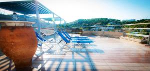 a balcony with chairs and a hammock on a building at Apollonia Hotel Apartments in Varkiza