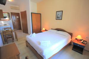 a bedroom with a large white bed and a table at Delphi Hotel in Neo Klima