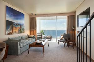 a living room with a couch and a view of the ocean at Les Suites at The Cliff Bay - PortoBay in Funchal