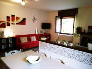 een woonkamer met een rode bank en een tafel bij Valtellinaguesthouse in Delebio