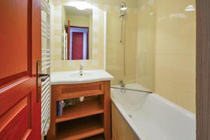 a bathroom with a sink and a bath tub and a mirror at Residence Les Terrasses d'Azur - maeva Home in Isola 2000 +19 photos