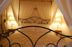 a bedroom with a canopy bed with two lamps at La Cantina in Alberobello