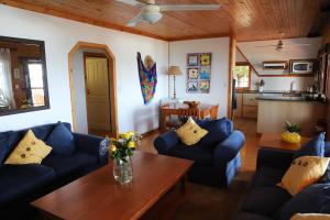 un soggiorno con divani blu e un tavolo in legno di Forest Homes 24 a Palm Beach
