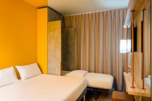 Postel nebo postele na pokoji v ubytování ibis budget Lyon Est Beynost
