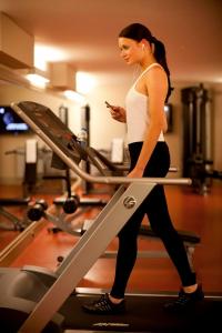 a woman on a treadmill while looking at her cell phone at Tunel Residence Pera in Istanbul