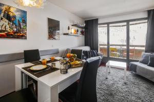 a kitchen and living room with a table and chairs at Residence Les Terrasses d'Azur - maeva Home in Isola 2000