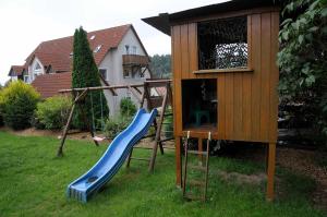 a playground with a slide and a play house at Ferienwohnungen Lehner in Mitteleschenbach