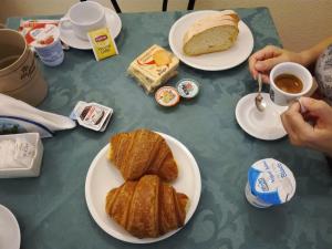 einen Tisch mit Tellern und einem Stück Kuchen in der Unterkunft Albergo Dei 10 Colori in Procchio