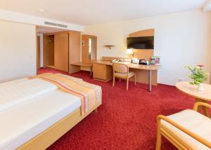 ein Hotelzimmer mit Bett und Schreibtisch in der Unterkunft Hotel Alarun Munich by Mayburgh in Unterschleißheim + 65 Fotos