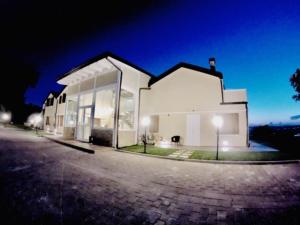 a large white building with glass windows at night at Agriturismo Tenuta Villa Catena in Paglieta