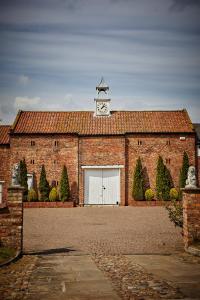 a brick building with a clock tower on top of it at Loftsome Bridge Hotel in Wressell