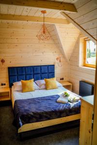 um quarto com uma cama azul num quarto de madeira em Domki u Czerników em Białka Tatrzanska