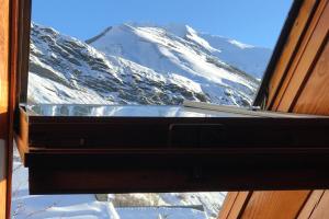 una ventana con vistas a una montaña nevada en Boréales - spacious duplex - in La Grave-La Meije heart en La Grave
