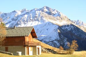 a cabin in front of a snow covered mountain at Le Serre Grau 2 pcs - Apartment facing South and the forest in Villar-dʼArène