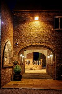 Wressell的住宿－Loftsome Bridge Hotel，夜间砖砌建筑的拱门