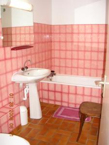 a pink tiled bathroom with a sink and a tub at Le Serre Grau 2 pcs - Apartment facing South and the forest in Villar-dʼArène