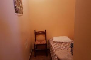 a small room with a bed and a chair at Le Serre Grou studioLarge studio at the gateway to the Ecrins National Park in Villar-dʼArène