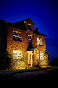 a brick house with a white door on a street at Loftsome Bridge Hotel in Wressell