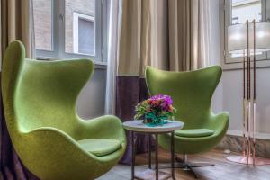 a green chair sitting in front of a window at Hotel Martis Palace in Rome
