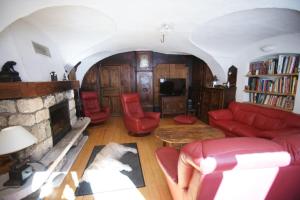 een woonkamer met een rode bank en een open haard bij Chez Jean Pierre - Bedroom in a 17th century house - n 4 in Villar-dʼArène