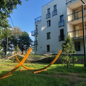 a hammock in the grass in front of a building at Apartament w parku nad Zatoką in Puck