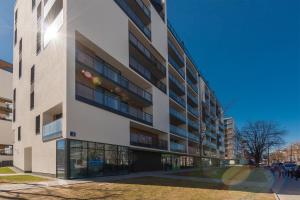 un edificio alto con gente caminando delante de él en P&O Apartments Mokotów, en Varsovia