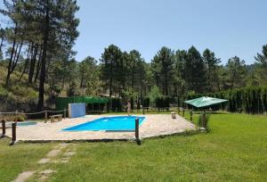 a person is standing near a swimming pool in a yard at Chalet lujo en finca Zafiro lagunazo Riopar 5 o 3 dormitorios y 3 Baños Parque Natural del Rio Mundo in Riópar