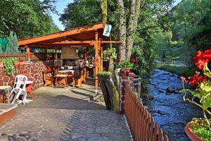 uma pérgola de madeira junto a um rio em House By The River em Teteven