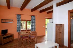 Una cocina y un comedor con mesa y sillas. en Finca Son Guardiola, en Llucmajor